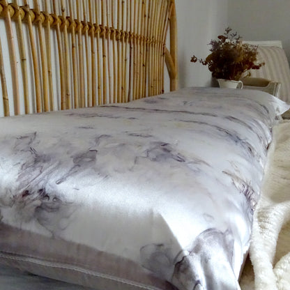 Détail de la texture soyeuse et des nuances naturelles mauve et ambre sur soie de mûrier artisanale